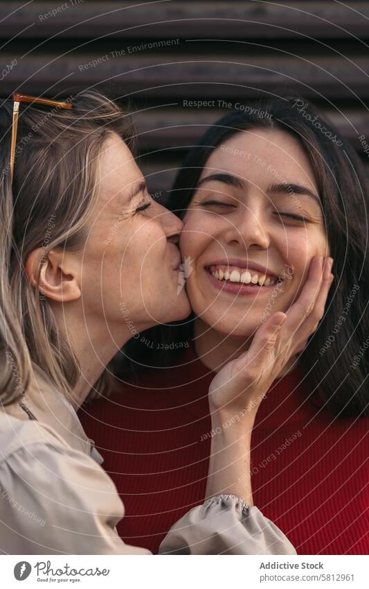 girl friends kissing on the cheek. Close-up. Blonde and brunette young people woman female happy beautiful together lifestyle smile portrait adult friendship