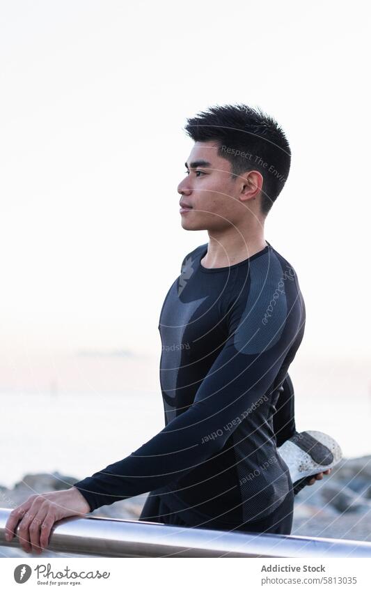 Ethnic man stretching legs during outdoor workout fitness training exercise sporty warm up sunset asian ethnic male sportsman lifestyle athlete wellness young