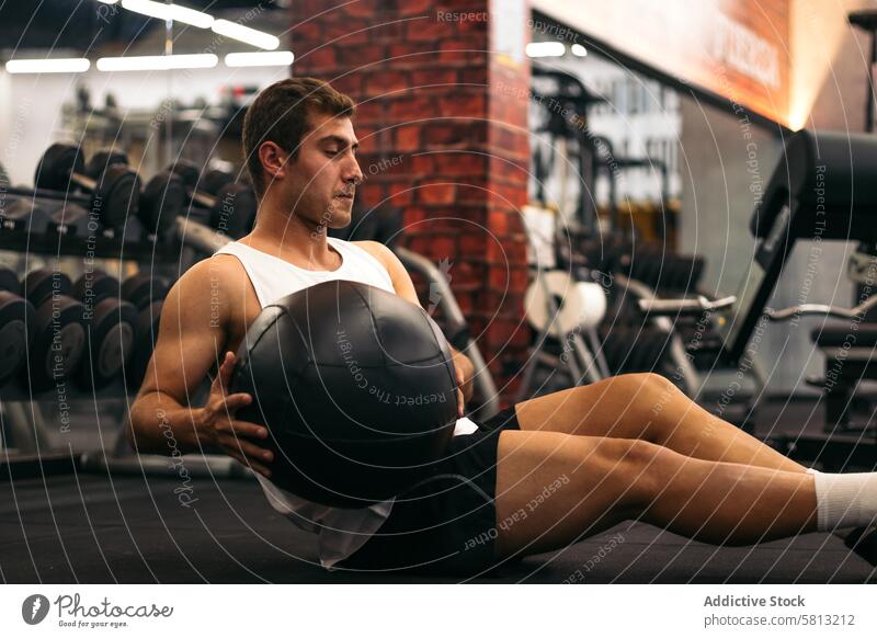 young man doing weight ball abs exercise in a gym training fitness workout muscular sport adult lifestyle strength body people active indoors athlete male