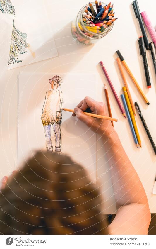 Top view of a fashion designer drawing a fashion sketch. Vertical shot 50s above clothing confidence confident creativity desk directly above dressmaker