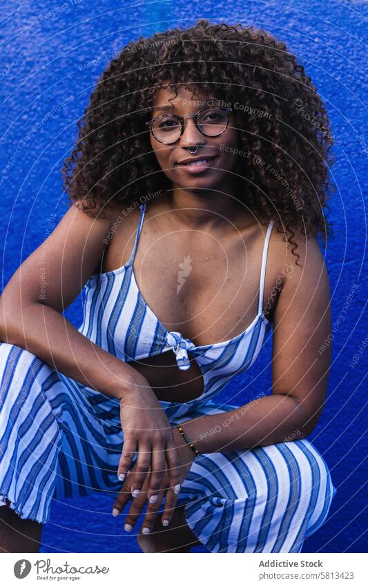 Trendy ethnic female against bright wall woman style street city yellow dress glasses young curly hair black african american trendy urban vivid contemporary