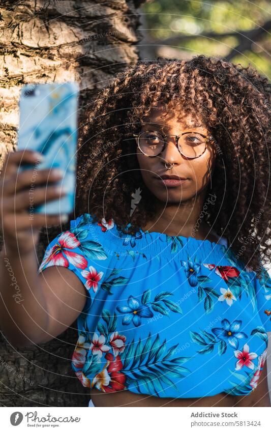 Glad black woman taking selfie near palm tree summer style smartphone weekend street rest female young ethnic african american glasses trunk casual trendy