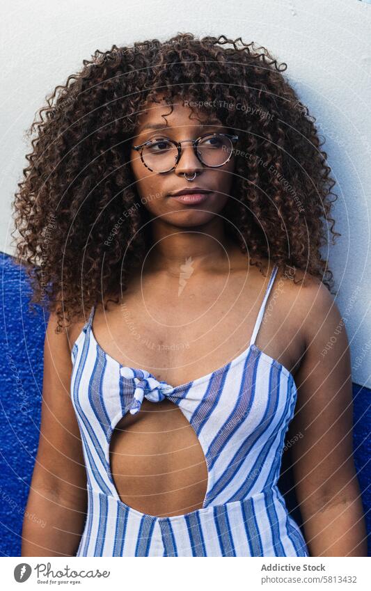 Trendy ethnic female against bright wall woman style street city yellow dress glasses young curly hair black african american trendy urban vivid contemporary