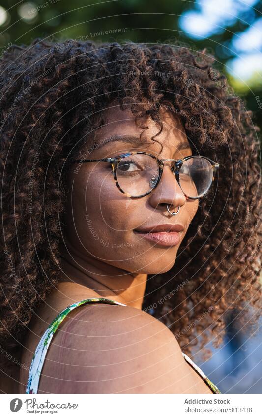 Glad African American woman looking at camera in park smile summer style happy curly hair glasses female cheerful black african american ethnic delight joy