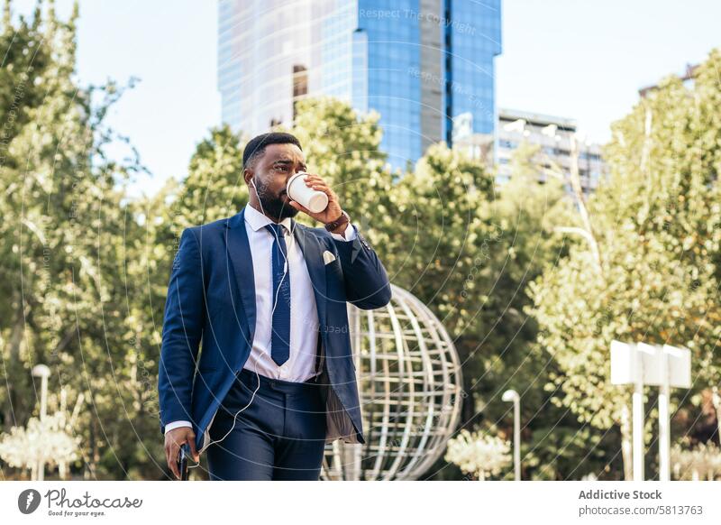 Business black man in suit leaving the office holding his smartphone and drinking a coffee business meeting professional executive success entrepreneur finance