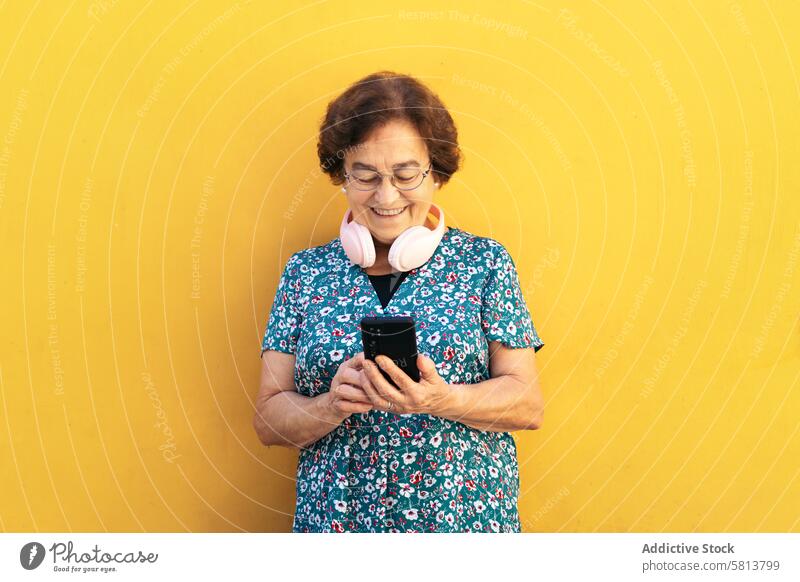 Smiling old woman using smartphone outdoors stylish mobile cellphone senior female communication device message lifestyle internet mobile phone people