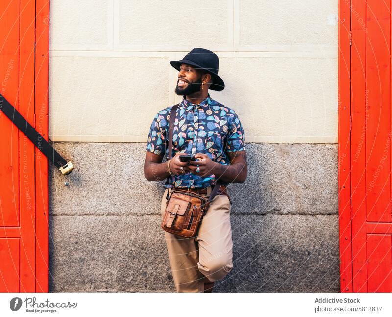 Stylish black man using smartphone outdoors in the city technology lifestyle young street urban mobile male person cellphone stylish guy outside people casual