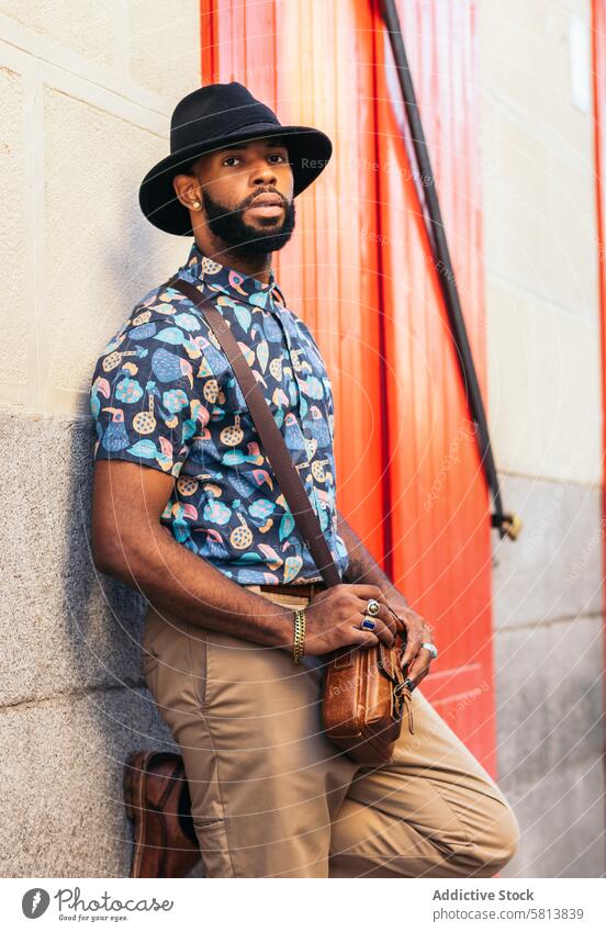 Portrait of a stylish black man in hat and alternative outfit lifestyle city young street urban male person guy outside people casual outdoors adult fashion