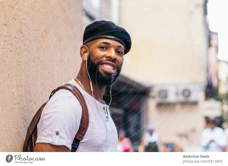 Stylish black man using smartphone and listening to music outdoors in the city technology lifestyle young street urban mobile male person cellphone stylish guy