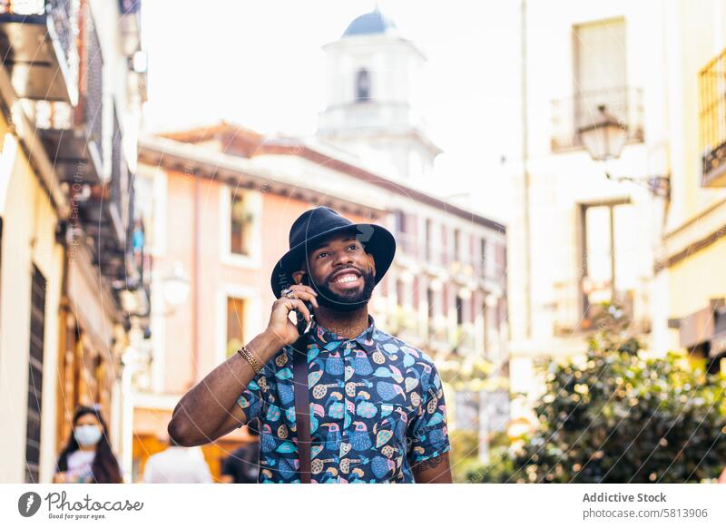 Stylish black man talking on the phone outdoors in the city technology lifestyle smartphone young street urban mobile male person using cellphone stylish guy
