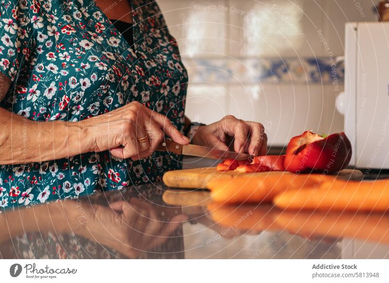 Elderly woman cooking with peppers in the kitchen at home elderly food senior happy old lifestyle adult grandmother healthy table people meal house grandma