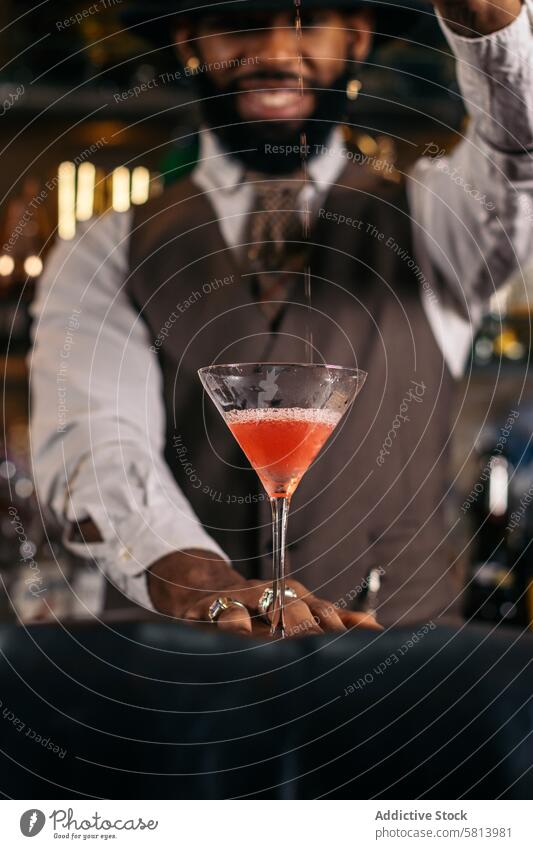 Black bartender preparing a cocktail in a traditional cocktail bar barman beverage mixologist nightclub black alcohol barkeeper glass drink work professional