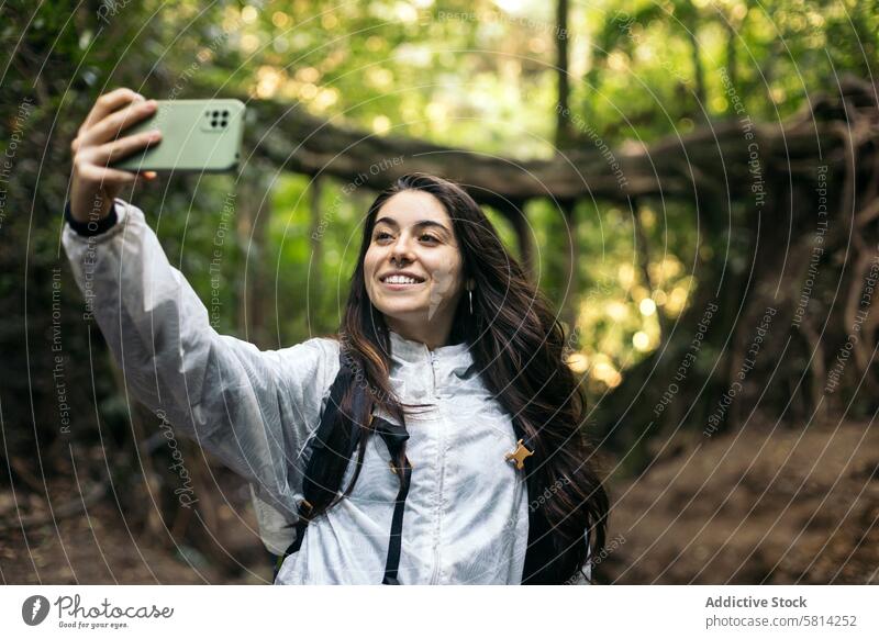 Woman taking selfies in the forest portrait outdoors nature lifestyle people vacation leisure looking hiking tree travel backpack autumn adventure closeup