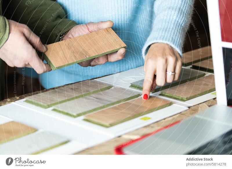 Anonymous woman choosing sample with carpenter in workshop artisan client choose order help joinery workbench female pick craftsman job industry manufacture