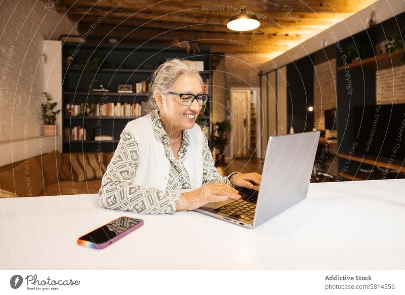 Senior woman using laptop at home 65-69 years One senior woman only active active seniors adult beautiful beauty communication computer connection device