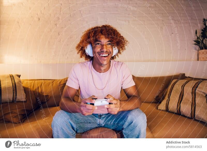 Young man playing video games african american ethnicity afro afro hairstyle attractive black black male black man casual clothing celebration connected