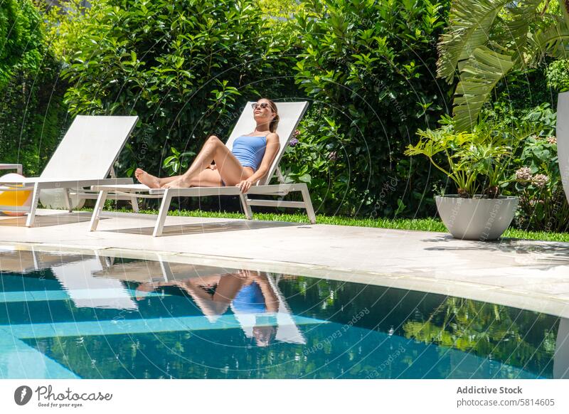 Beatiful woman relaxing by the pool at a luxury hotel. Copy space adult attractive beautiful beauty beverage bikini carefree caucasian chair charming cocktails