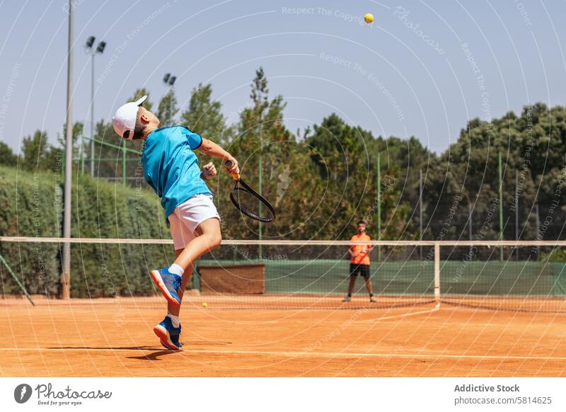 Boy playing tennis with his coach on a dirt court activity sport game racket person player athlete training lifestyle healthy exercise ball happy athletic hobby