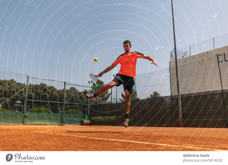 Man in sportswear playing tennis on a dirt tennis court activity game racket person player athlete training lifestyle healthy exercise ball happy athletic hobby