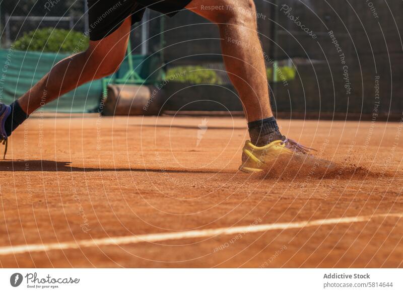 Man in sportswear playing tennis on a dirt tennis court activity game racket person player athlete training lifestyle healthy exercise ball happy athletic hobby