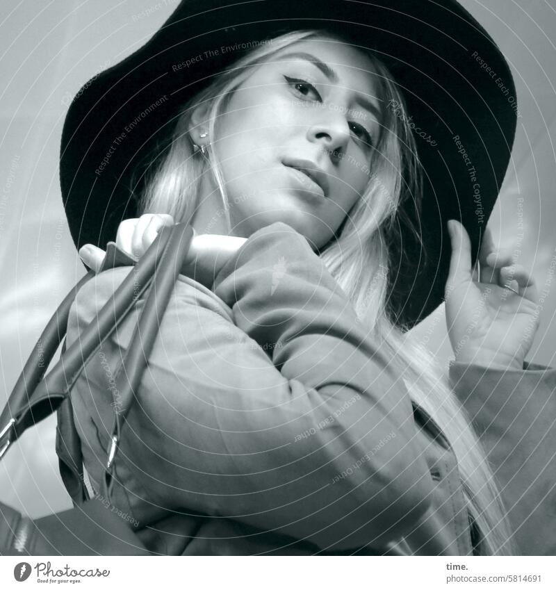 Woman with hat and bag Hat Bag Feminine portrait Hand Downward Looking into the camera Coat Blonde Long-haired Movement Observe Face look Lifestyle