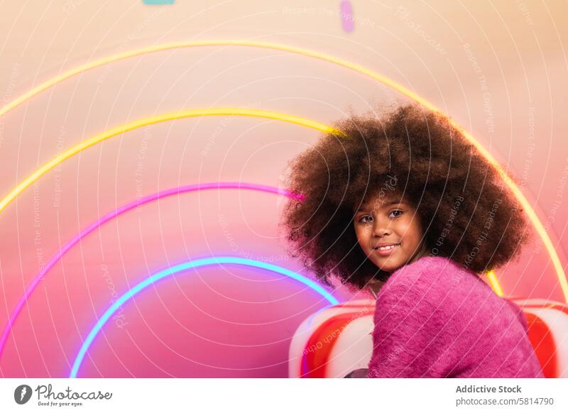 Teenage girl in colorful studio bright vivid afro hairstyle appearance teenage ethnic black african american illuminate model fashion neon vibrant curly hair
