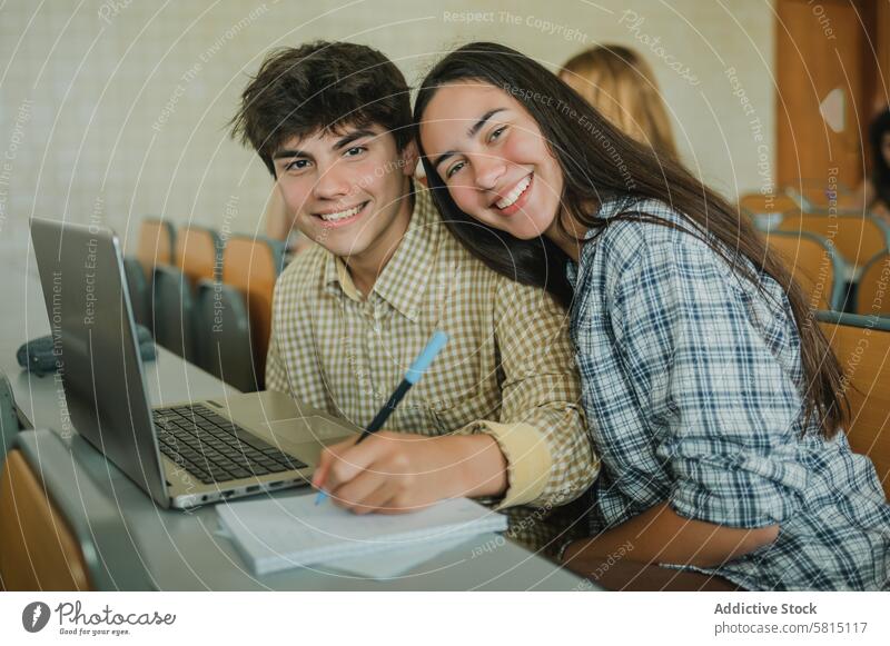 Happy teen couple during lecture in university student lesson smile write note together education portrait study lean girlfriend boyfriend teenager young