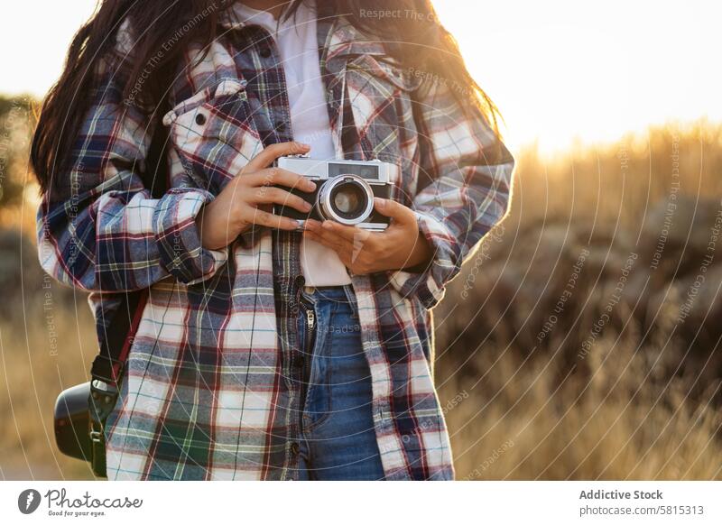 Unrecognizable woman taking photos with analog camera at sunset lifestyle young girl photography vintage retro travel hipster photographer beautiful people