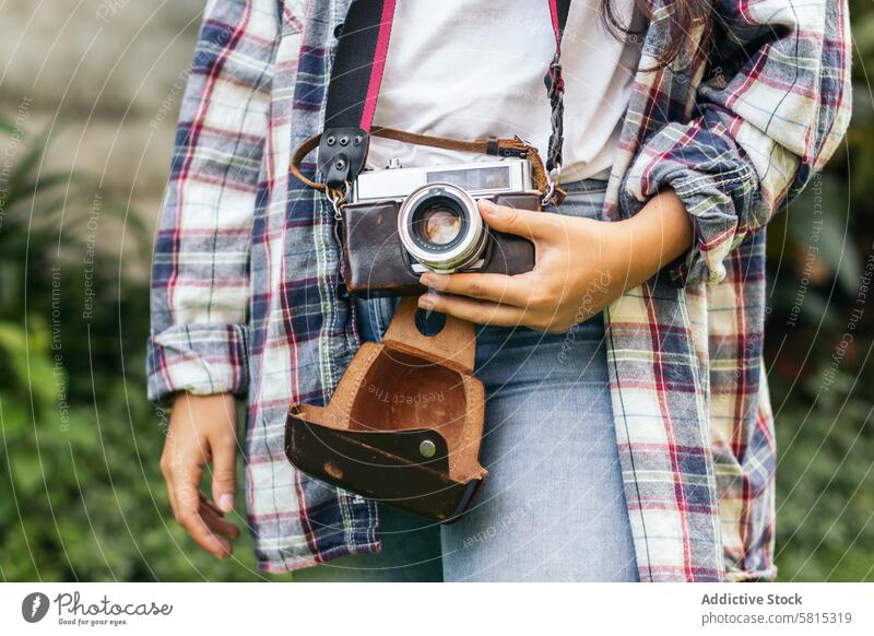 Unrecognizable woman taking photos with analog camera in the field at sunset lifestyle young girl photography vintage retro travel hipster photographer