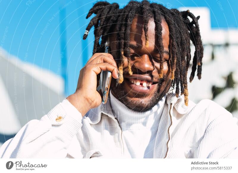 Cheerful black man talking on smartphone selfie dreadlocks style hairstyle trendy cheerful unique male ethnic african american outfit gadget urban young mobile