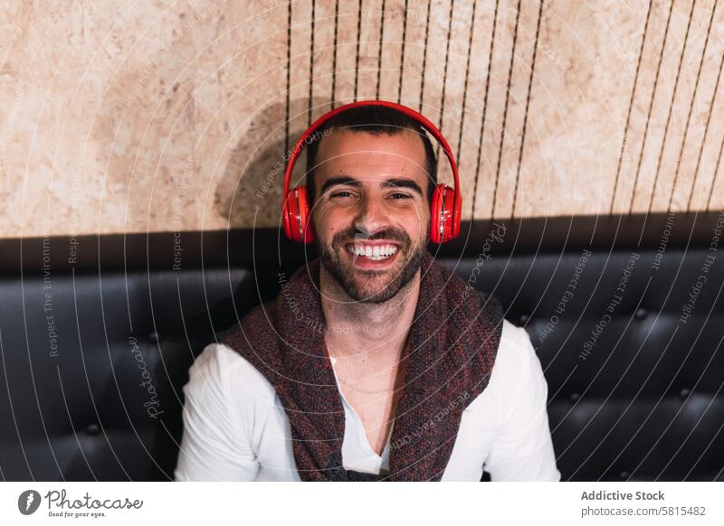 Happy man listening to music smile happy meloman hobby headphones wireless male adult enjoy cheerful entertain glad content song sound melody audio tune modern