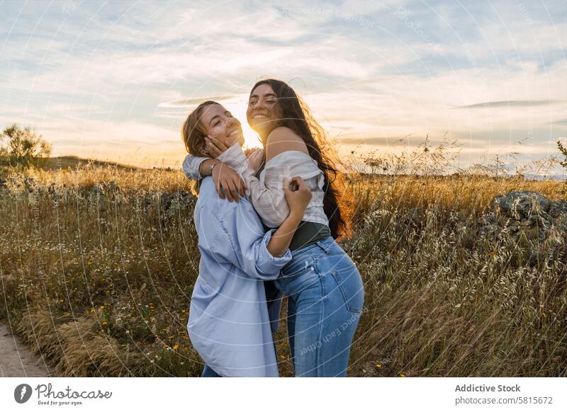 two young women hugging on a field during sunset couple woman together love romance nature family happy lifestyle relationship female happiness girl people
