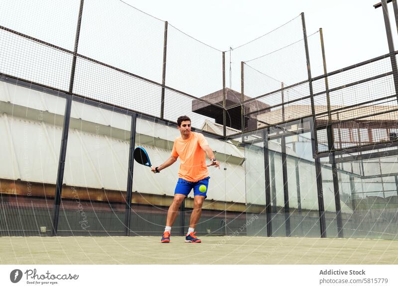 young man playing paddle tennis sport court recreation racket game lifestyle male player leisure action serve net healthy adult ball active men outdoor fit