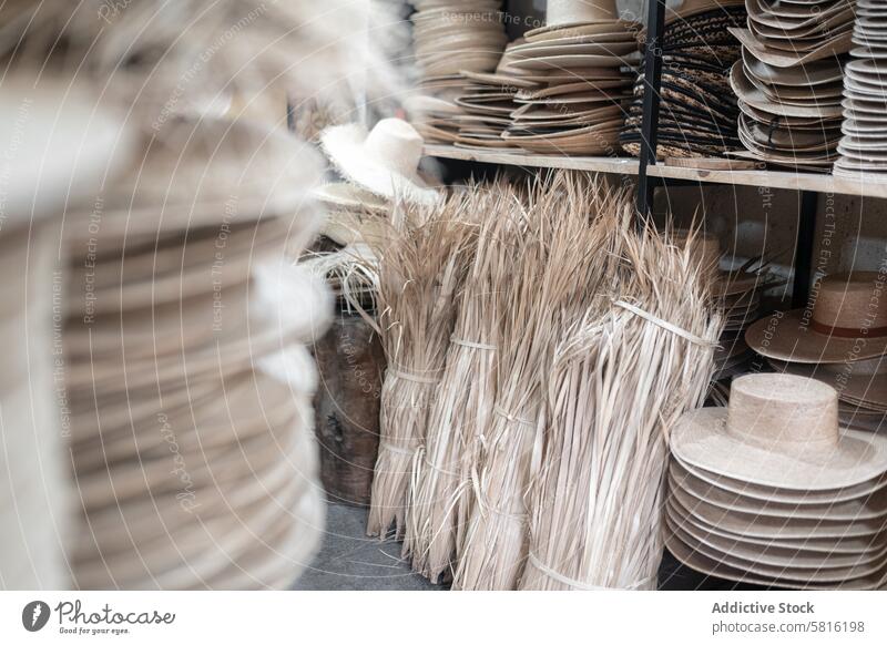Some palm tree fiber stacks in a hat workshop natural fiber warehouse craft block millinery tailor process production manufacture design fashion material hay
