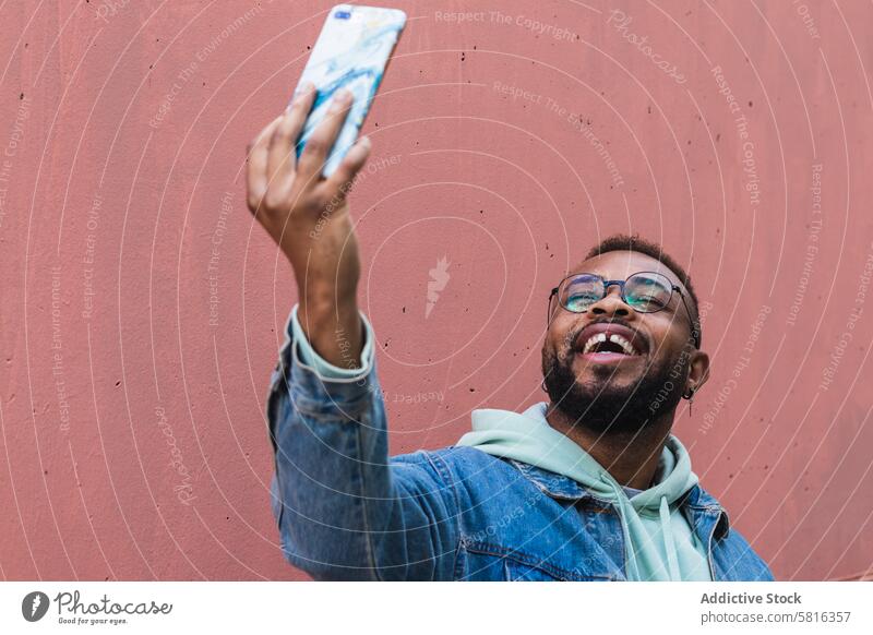 Happy ethnic man taking selfie on smartphone happy hipster cheerful mobile photography using take photo adult black african american male casual device gadget