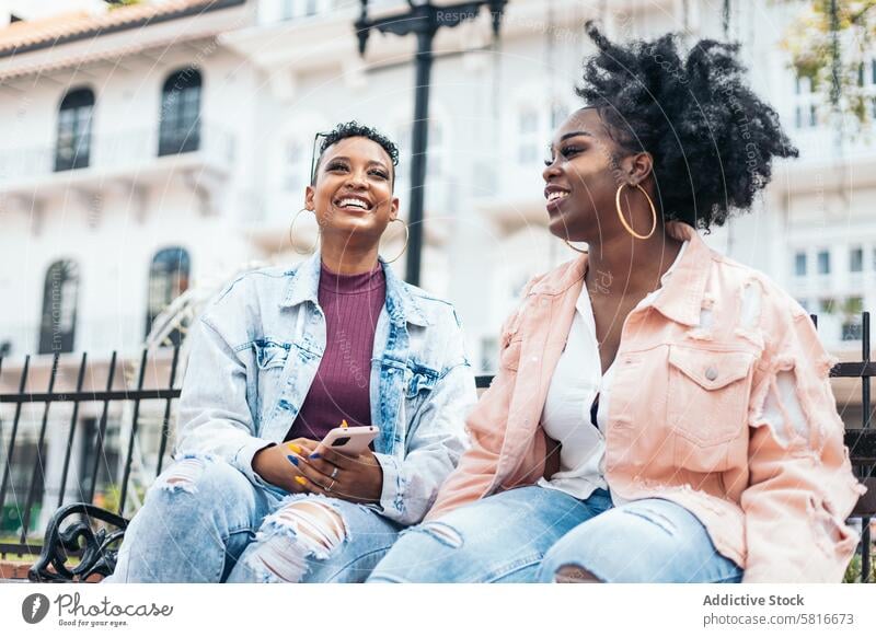 African american women talking and laughing in the city happy young summer woman female outdoors people leisure lifestyle photo joyful looking spring enjoyment