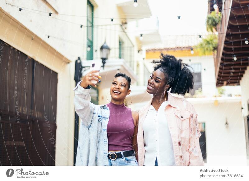 Happy women taking selfies with smartphone walking in the city happy young summer woman female outdoors people fun leisure smile lifestyle photo attractive