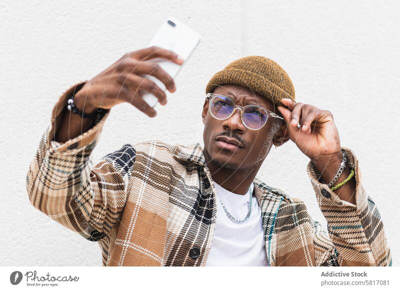 Stylish black man taking selfie style street urban smartphone casual frown city modern male ethnic african american cool outfit lifestyle glasses trendy