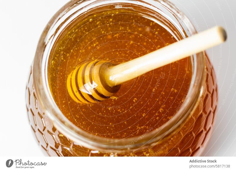 Dipper stirring fresh aromatic golden honey in glass jar dipper natural sweet healthy beekeeping food drip delicious organic ingredient tasty treat meal flavor