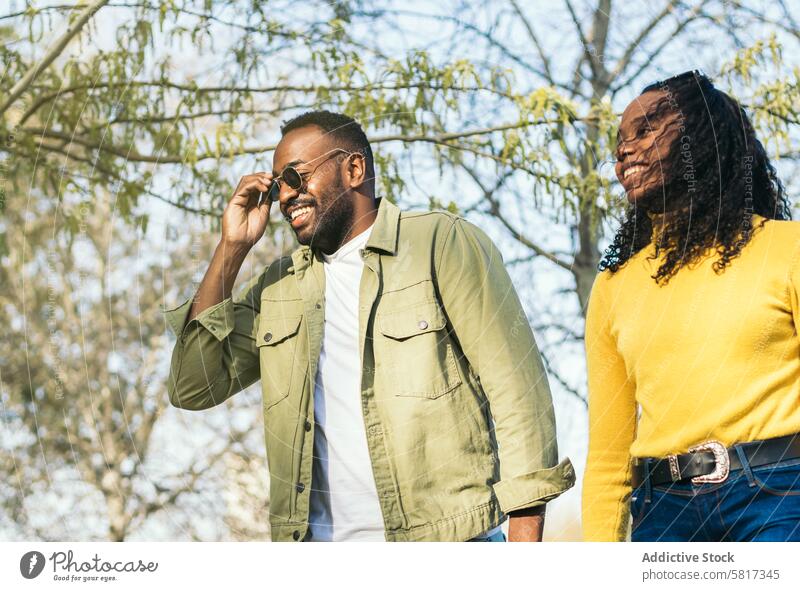 handsome afro-american young man and his sister walking in a park black male happy african lifestyle casual portrait person people adult outdoors guy fun