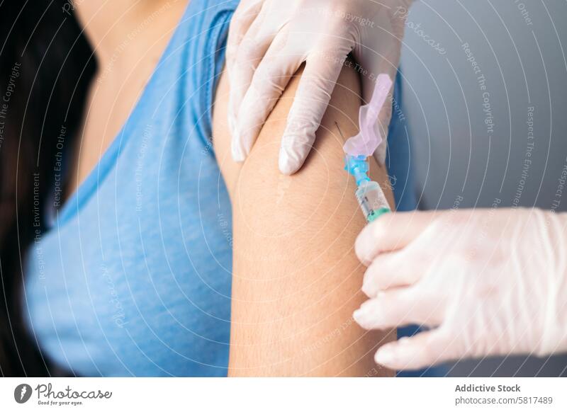 Vaccine in injection needle. Doctor working with patient's arm. Physician or nurse giving vaccination and immunity to virus, influenza or HPV with syringe. Appointment with medical expert. Close-up