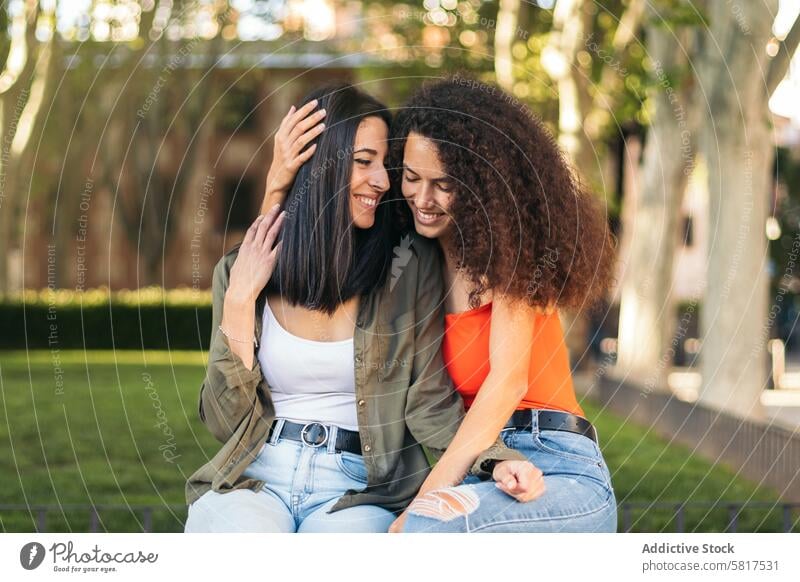 two young women couple sitting hugging. lesbian couple. interracial woman happy together love people romantic relationship girl female lifestyle casual