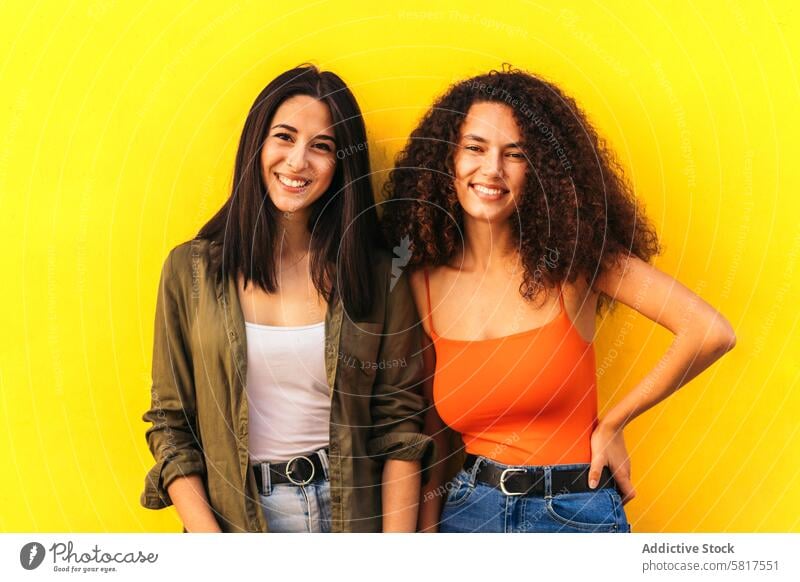 two stylish young women portrait. afro and caucasian curly hair beautiful female happy people girl woman beauty lifestyle pretty together attractive smile white