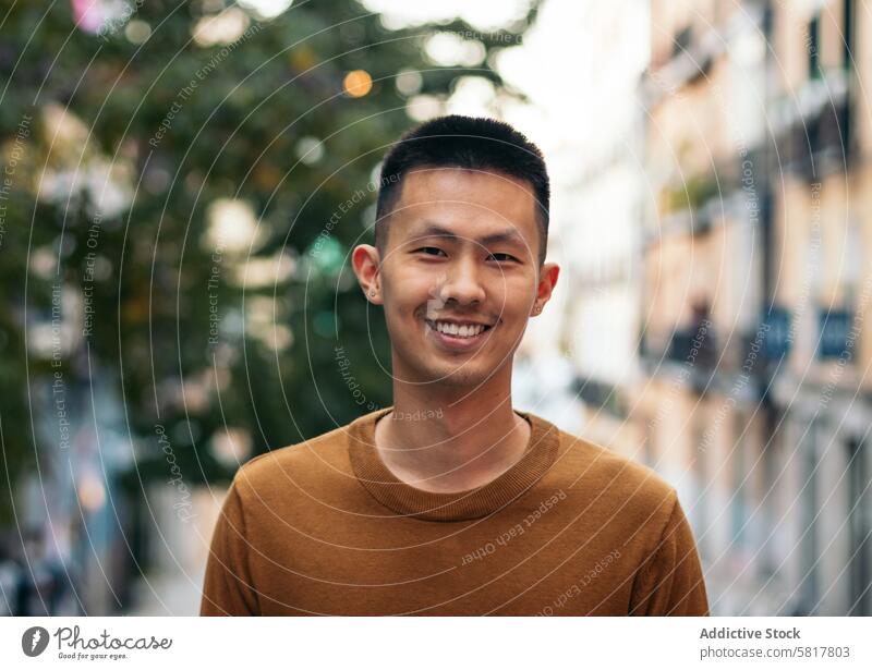 Portrait of a smiling Asian man outdoors asian people lifestyle happiness casual cheerful leisure street europe portrait standing happy person smile looking