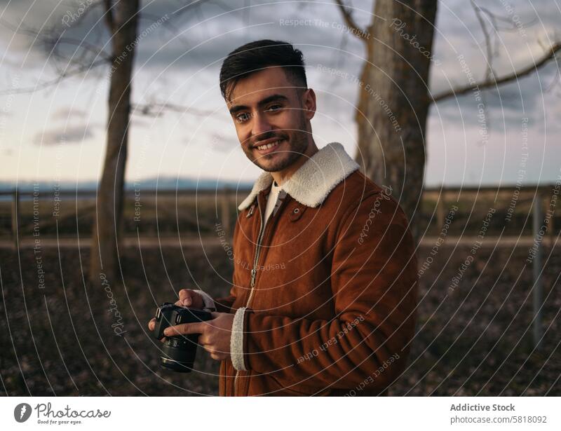 Portrait of a photographer taking photos in the countryside camera photography nature natural light outdoors lifestyle winter sky jacket alone travel calm