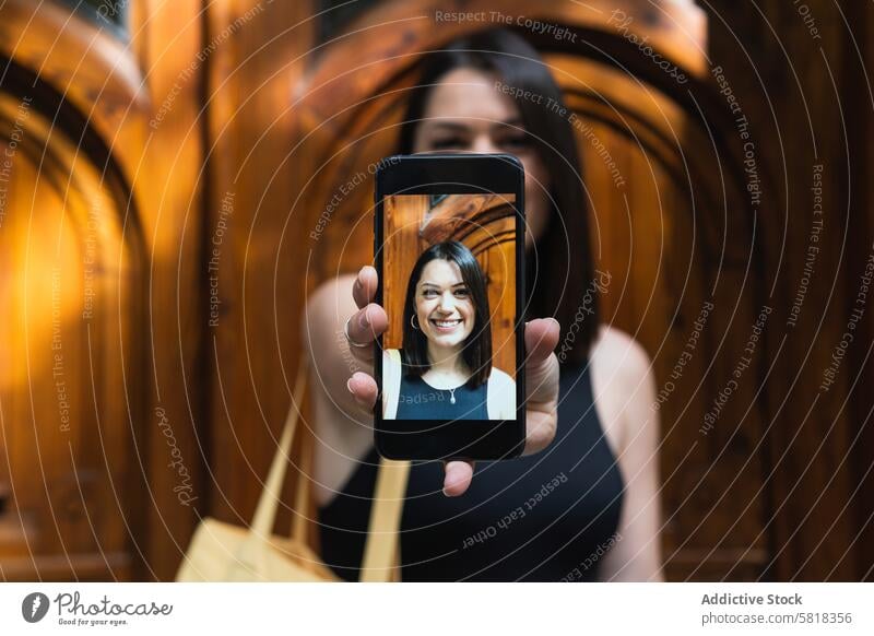 Delighted woman taking selfie on smartphone in city mobile self portrait cheerful having fun photo memory female moment happy device positive photography gadget