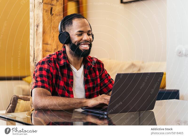 African american man teleworking with laptop from home computer african american internet freelance remote online using black modern indoors distance job device