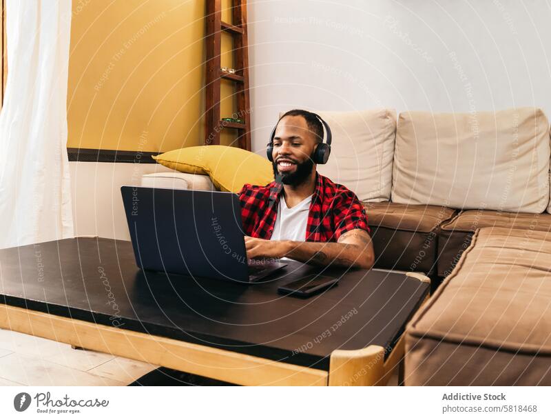 Black man teleworking with laptop from home computer african american internet freelance remote online using black modern indoors distance job device lifestyle