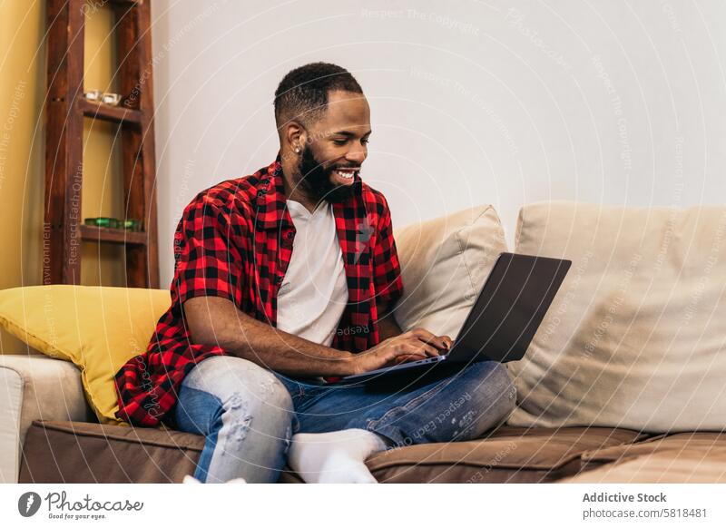Black man teleworking with laptop from home computer african american internet freelance remote online using black modern indoors distance job device lifestyle
