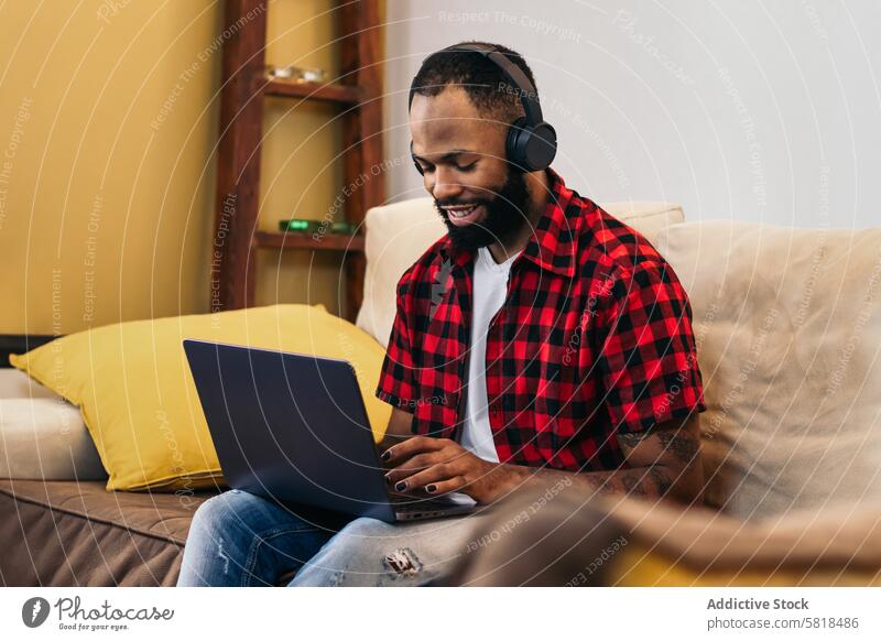 African american man teleworking with laptop from home computer african american internet freelance remote online using black modern indoors distance job device